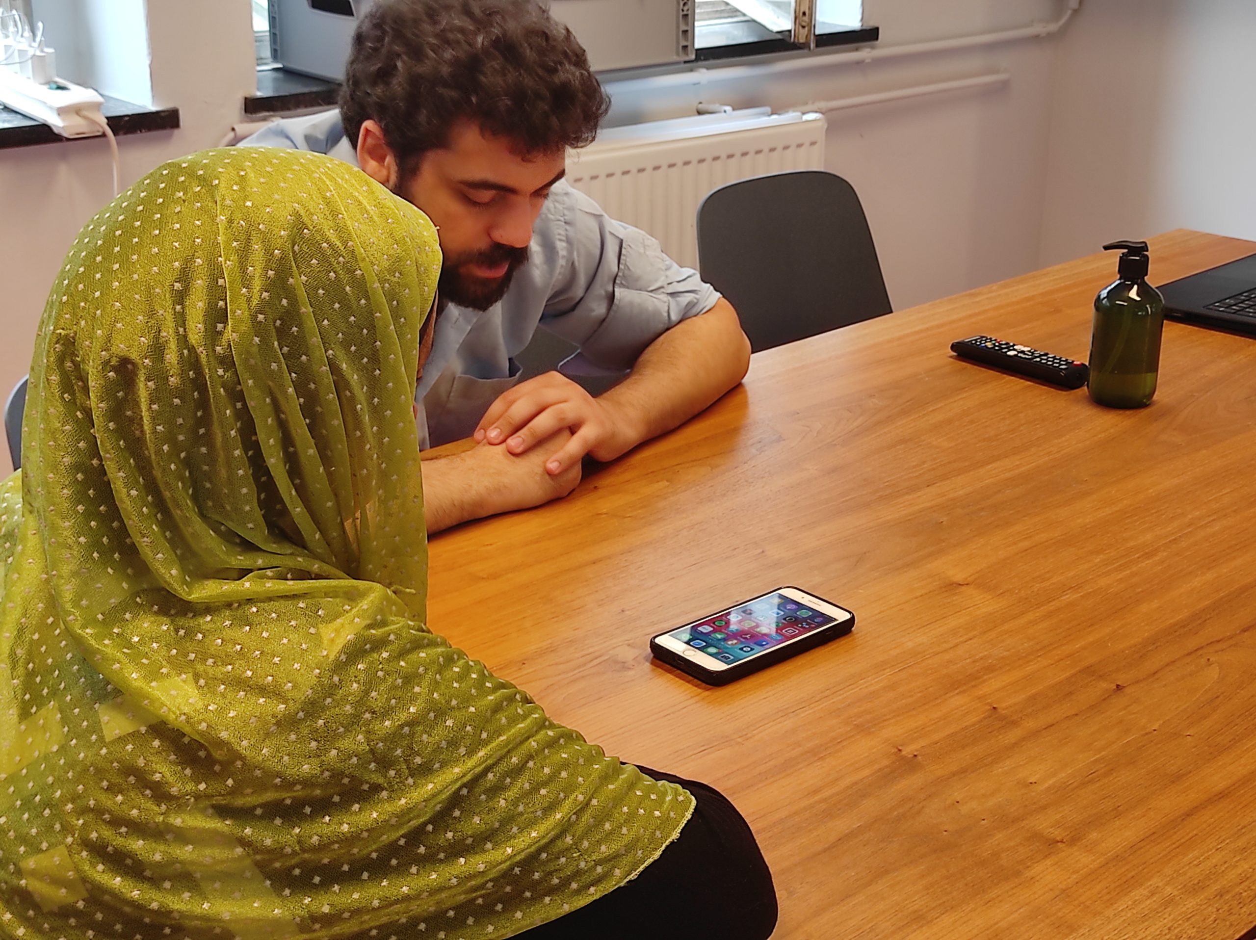 Une apprenante et un formateur découvrent un smartphone à la Digital Academy 1,2,3 DiGiT